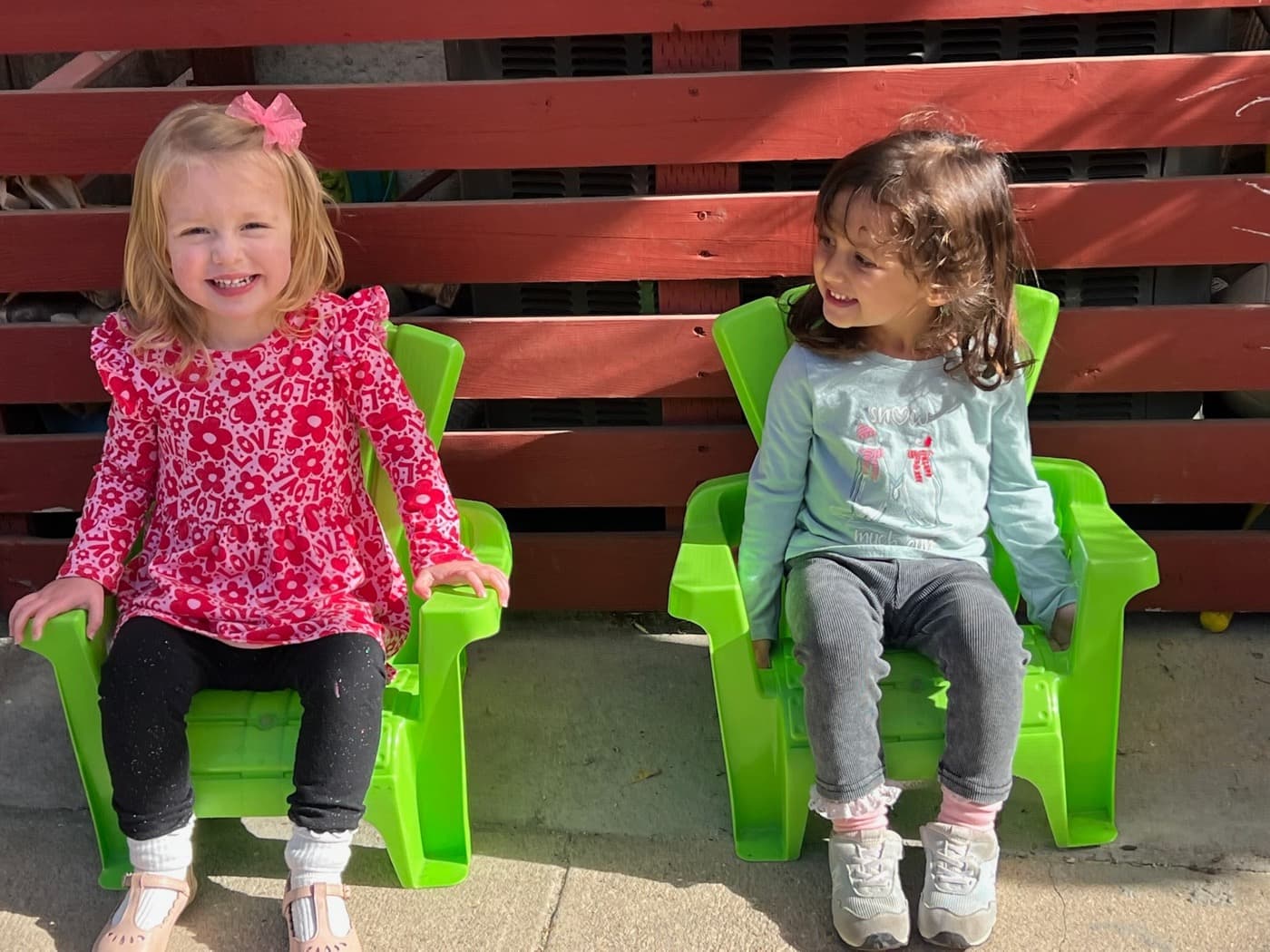 Two friends beaming together in little green chairs